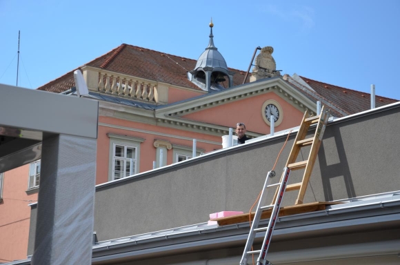 ArbeiterSchautVomDachUmbauAmHauptplatzWrNeustadtFotoPeWoe